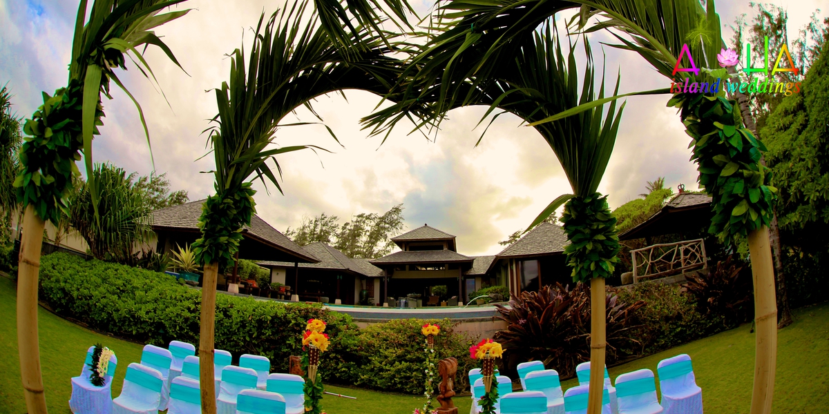 Garden ceremony setup with blue chairs under the palm trees at the estate house
